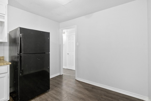 713 Hyacinth St, North Little Rock, AR 72117 - kitchen with freestanding refrigerator, dark wood-type flooring, white cabinetry, baseboards, and a textured ceiling