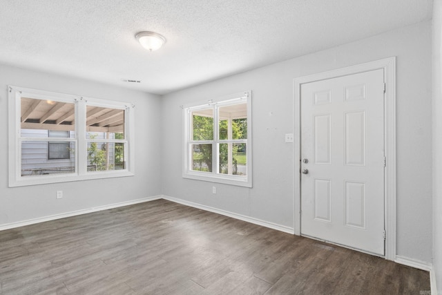 713 Hyacinth St, North Little Rock, AR 72117 - entryway featuring dark wood-type flooring, a textured ceiling, and baseboards