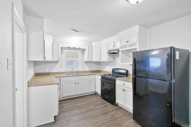 713 Hyacinth St, North Little Rock, AR 72117 - kitchen with black appliances, a sink, under cabinet range hood, light wood-type flooring, and white cabinets