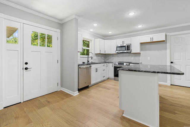 912 Bumpus Rd, Alexander, AR 72002 - kitchen with appliances with stainless steel finishes, light wood-type flooring, dark stone countertops, a sink, and ornamental molding