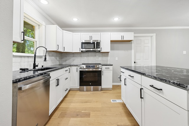 912 Bumpus Rd, Alexander, AR 72002 - kitchen with stainless steel appliances, a sink, light wood finished floors, dark stone countertops, and crown molding