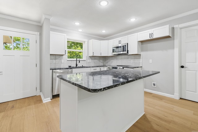 912 Bumpus Rd, Alexander, AR 72002 - kitchen with appliances with stainless steel finishes, a sink, light wood finished floors, white cabinets, and ornamental molding