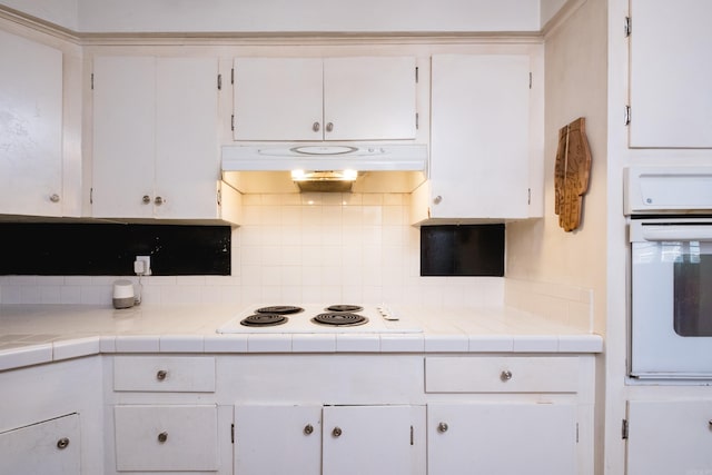 4500 Glenmere Rd, North Little Rock, AR 72116 - kitchen with white appliances, ventilation hood, white cabinetry, and backsplash