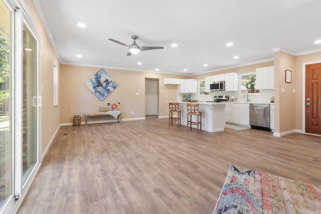 6513 Corsica Dr, North Little Rock, AR 72116 - kitchen with stainless steel appliances, crown molding, white cabinets, baseboards, and light countertops