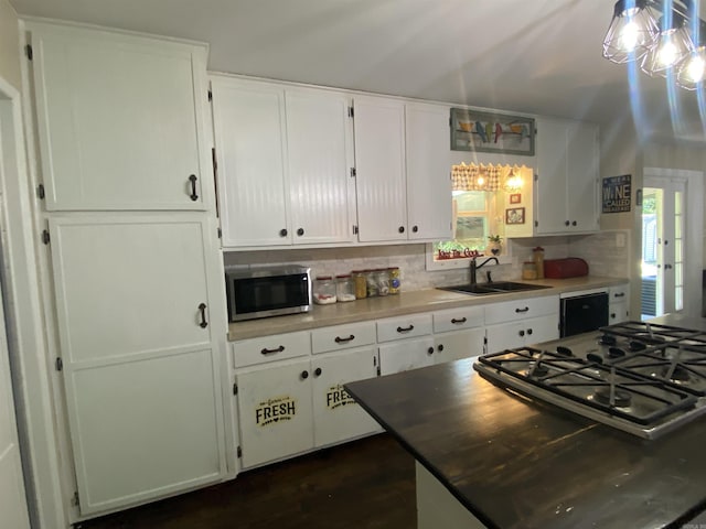 16 Mockingbird Ln, Story, AR 71970 - kitchen featuring stainless steel microwave, a sink, stovetop, decorative backsplash, and white cabinets