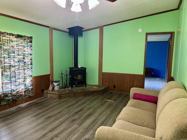 1263 Lost Creek Rd, Pearcy, AR 71964 - living area with a wood stove, wood finished floors, a textured ceiling, a ceiling fan, and wood walls