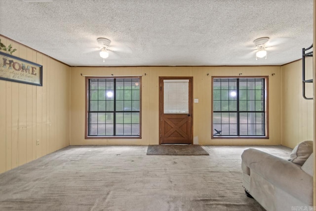 766 Grant 735 Rd, Sheridan, AR 72150 - entryway featuring ceiling fan, carpet flooring, a textured ceiling, and wooden walls