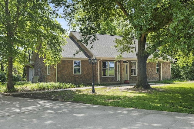 645 Drye Rd, Biscoe, AR 72017 - view of front of property featuring stone siding, a shingled roof, a front lawn, and central AC