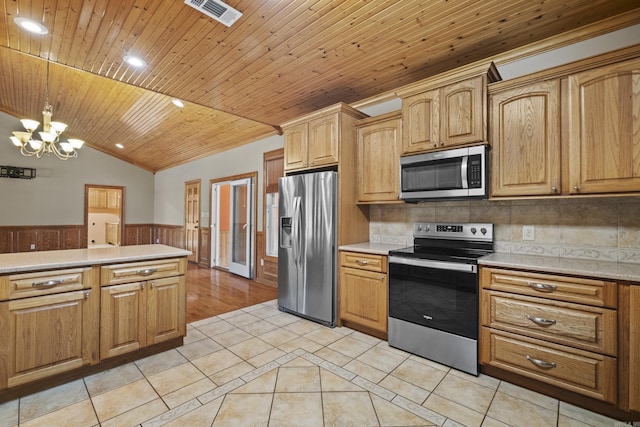 645 Drye Rd, Biscoe, AR 72017 - kitchen with stainless steel appliances, wainscoting, light tile patterned flooring, a chandelier, and light countertops