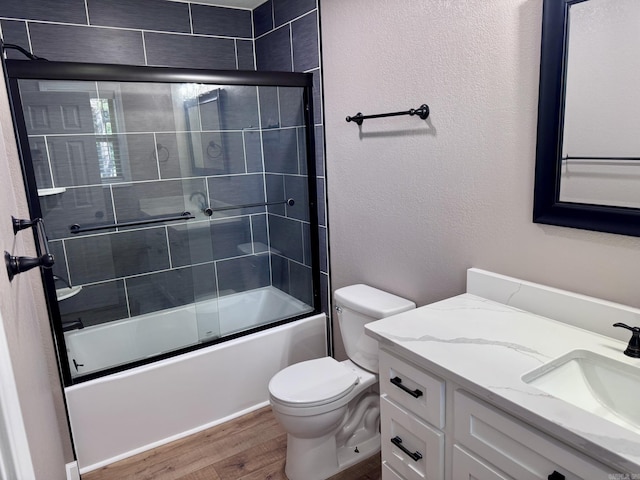 2174 N Main St, Melbourne, AR 72556 - full bath featuring wood finished floors, vanity, toilet, and bath / shower combo with glass door