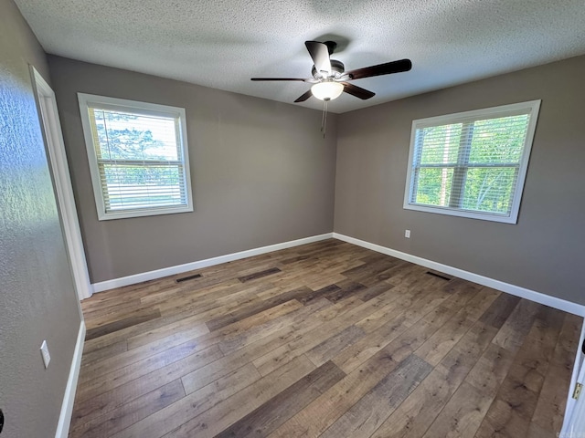 2174 N Main St, Melbourne, AR 72556 - empty room featuring ceiling fan, healthy amount of natural light, hardwood / wood-style flooring, a textured ceiling, and baseboards