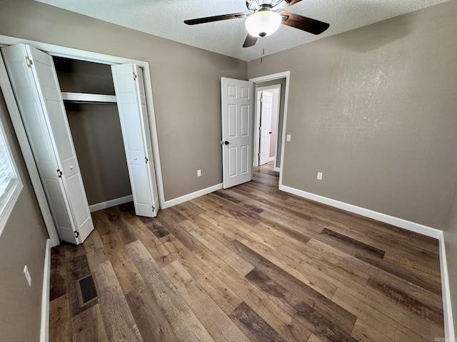 2174 N Main St, Melbourne, AR 72556 - unfurnished bedroom with wood finished floors, baseboards, a textured ceiling, ceiling fan, and a closet
