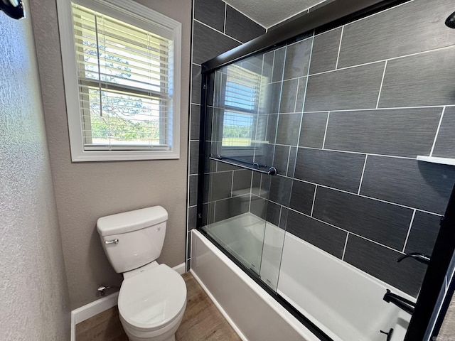 2174 N Main St, Melbourne, AR 72556 - full bath featuring toilet, bath / shower combo with glass door, wood finished floors, and baseboards