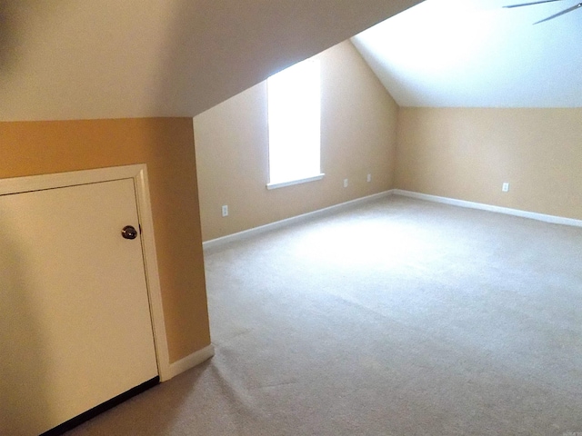 bonus room featuring lofted ceiling, carpet flooring, and baseboards