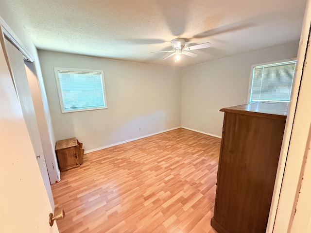 147 Winfree Ln, Melbourne, AR 72556 - unfurnished bedroom featuring light wood-style flooring, a ceiling fan, baseboards, and a textured ceiling