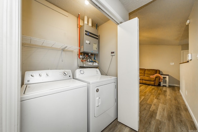 13 Fieldcrest Ln, Cabot, AR 72023 - laundry room with tankless water heater, wood finished floors, washer and clothes dryer, and baseboards
