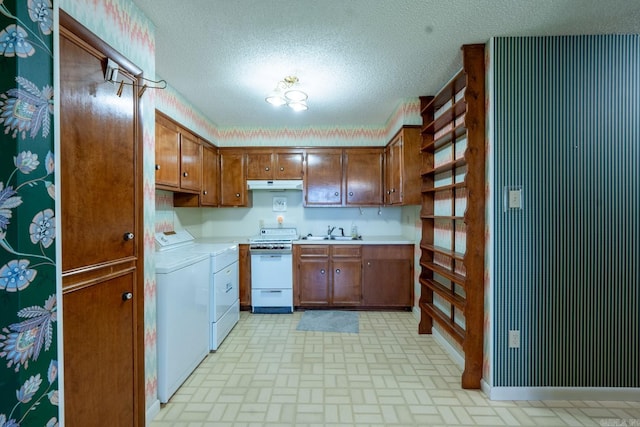 265 Zebulin Dr, Heber Springs, AR 72543 - kitchen with white gas range oven, independent washer and dryer, under cabinet range hood, brown cabinetry, and brick patterned floors
