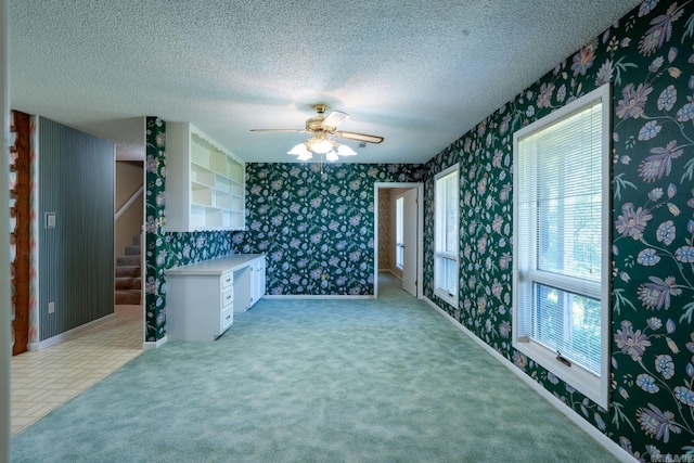 265 Zebulin Dr, Heber Springs, AR 72543 - spare room featuring wallpapered walls, a textured ceiling, ceiling fan, stairway, and light carpet