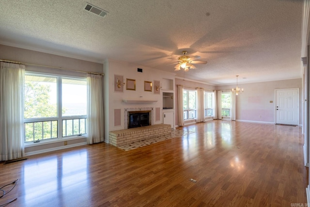 265 Zebulin Dr, Heber Springs, AR 72543 - unfurnished living room with a textured ceiling, a chandelier, ornamental molding, ceiling fan, and wood finished floors