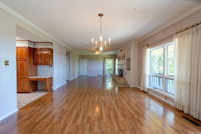 265 Zebulin Dr, Heber Springs, AR 72543 - unfurnished living room with a chandelier, light wood-style floors, a textured ceiling, baseboards, and ornamental molding