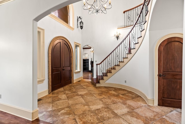 31 Cravache Ct, Little Rock, AR 72223 - foyer with stone tile floors, stairs, arched walkways, baseboards, and a high ceiling