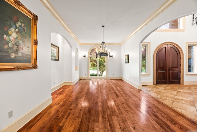 31 Cravache Ct, Little Rock, AR 72223 - entryway with arched walkways, a chandelier, crown molding, wood finished floors, and baseboards