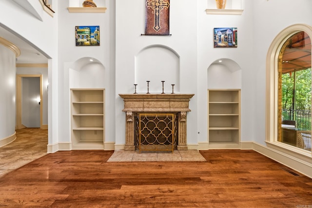 31 Cravache Ct, Little Rock, AR 72223 - living area with a high ceiling, a fireplace, wood finished floors, and baseboards