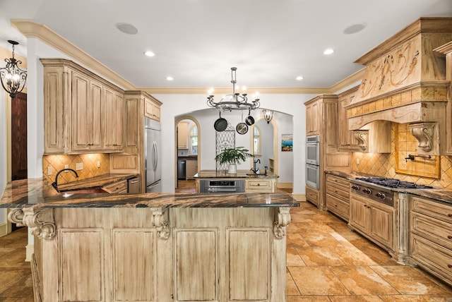 31 Cravache Ct, Little Rock, AR 72223 - kitchen featuring arched walkways, appliances with stainless steel finishes, a sink, a center island, and tasteful backsplash