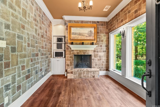 31 Cravache Ct, Little Rock, AR 72223 - unfurnished living room with ornamental molding, baseboards, a chandelier, wood finished floors, and a fireplace