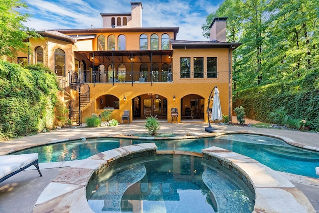 31 Cravache Ct, Little Rock, AR 72223 - rear view of house featuring stairs, a pool with connected hot tub, a patio area, a chimney, and a balcony