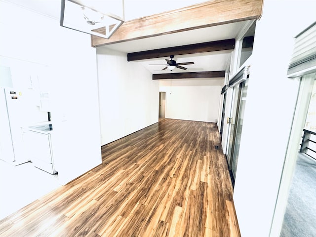 empty room featuring a ceiling fan, wood finished floors, and beamed ceiling
