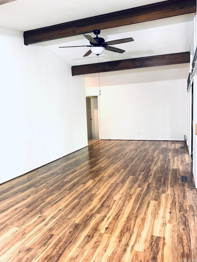 unfurnished room with beamed ceiling, a ceiling fan, and wood finished floors
