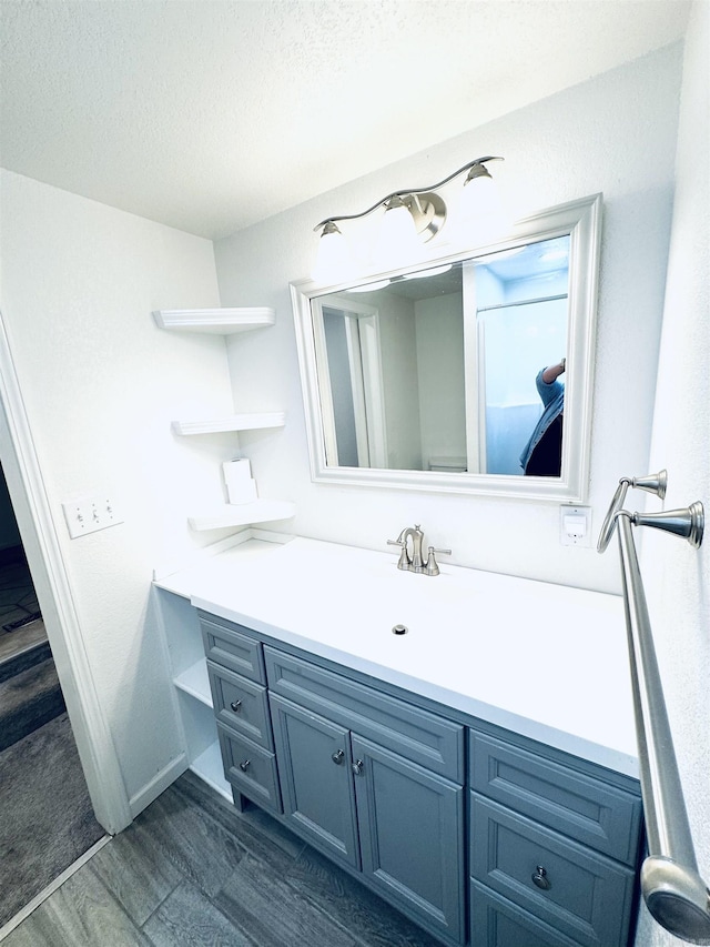 bathroom featuring vanity, a textured ceiling, and wood finished floors
