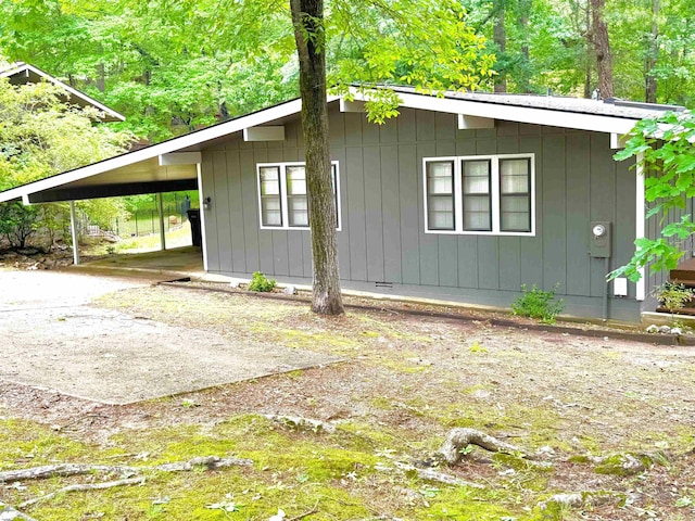 view of side of home with a carport and driveway