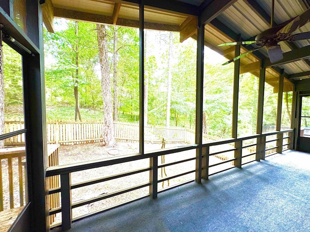 unfurnished sunroom with ceiling fan