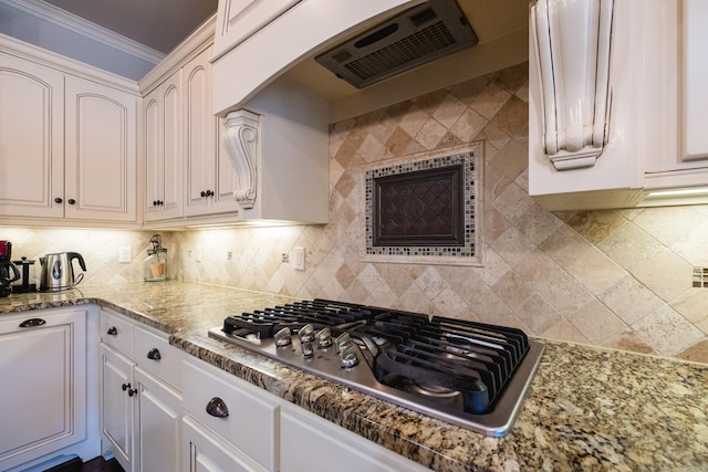 6 W Lake Ln, Little Rock, AR 72210 - kitchen with stainless steel gas cooktop, exhaust hood, ornamental molding, arched walkways, and tasteful backsplash