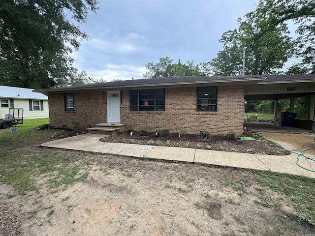 single story home with brick siding, an attached carport, and concrete driveway