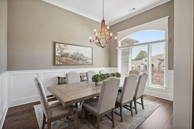 2059 Sloan Lake Dr, Jonesboro, AR 72404 - dining room with a chandelier, healthy amount of natural light, a wainscoted wall, a decorative wall, and dark wood-style flooring