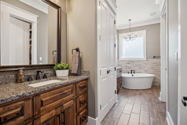 2059 Sloan Lake Dr, Jonesboro, AR 72404 - bathroom featuring vanity, crown molding, a soaking tub, a chandelier, and a closet