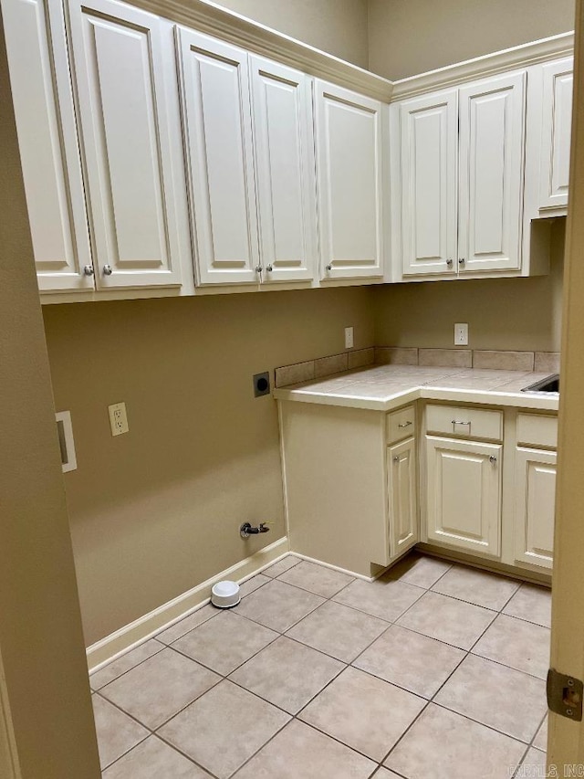 10 Calumet Rd, Little Rock, AR 72223 - laundry room with gas dryer hookup, electric dryer hookup, cabinet space, light tile patterned floors, and baseboards