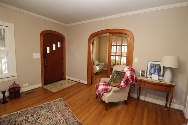 605 School St, Sheridan, AR 72150 - foyer featuring arched walkways, wood finished floors, ornamental molding, baseboards, and plenty of natural light