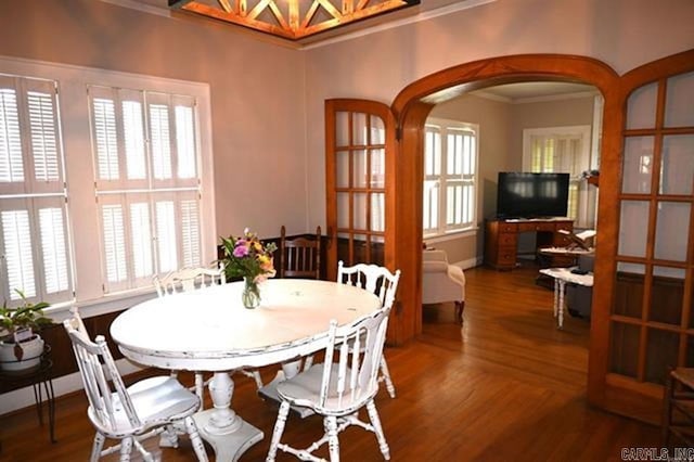 605 School St, Sheridan, AR 72150 - dining space featuring ornamental molding, arched walkways, wood finished floors, and plenty of natural light