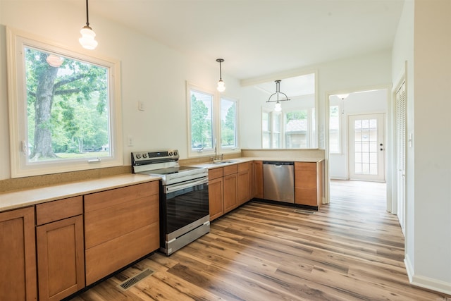 919 River Rdg, Benton, AR 72019 - kitchen featuring stainless steel appliances, a sink, healthy amount of natural light, and light wood-style flooring
