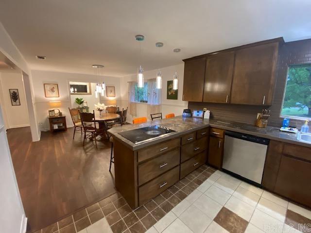 8 Westbrook Cv, Little Rock, AR 72205 - kitchen with stainless steel dishwasher, black electric stovetop, hanging light fixtures, a peninsula, and dark brown cabinetry
