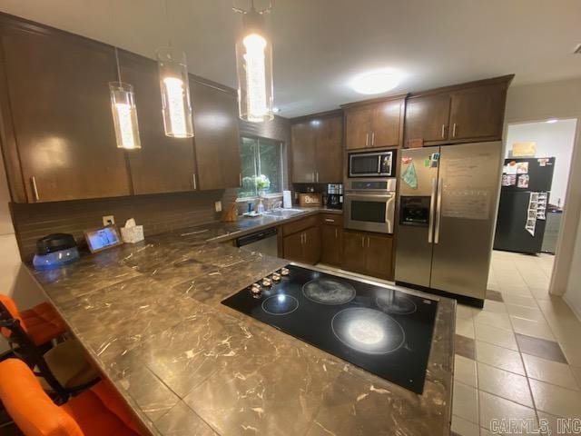 8 Westbrook Cv, Little Rock, AR 72205 - kitchen with stainless steel appliances, light tile patterned floors, a peninsula, and a breakfast bar