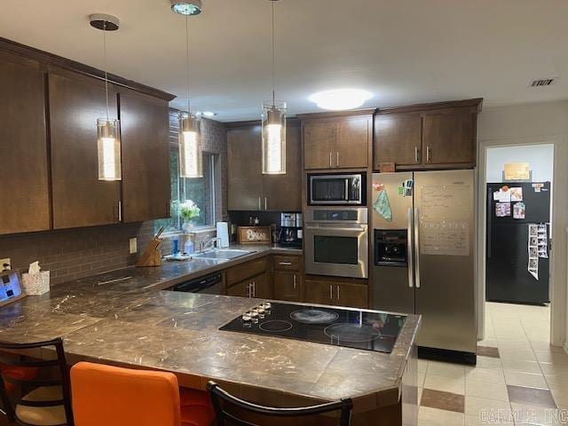 8 Westbrook Cv, Little Rock, AR 72205 - kitchen featuring appliances with stainless steel finishes, dark countertops, a peninsula, and dark brown cabinetry