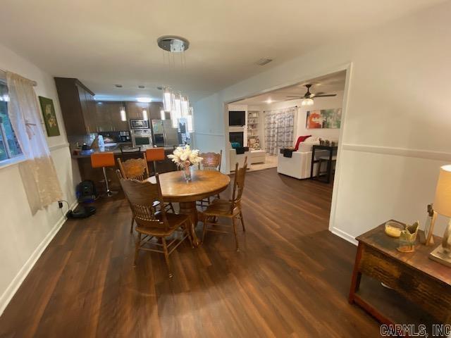 8 Westbrook Cv, Little Rock, AR 72205 - dining space with dark wood finished floors, ceiling fan, a fireplace, and baseboards