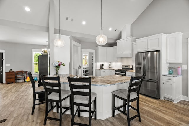 170 Irene Cir, Greenbrier, AR 72058 - kitchen featuring stainless steel appliances, a peninsula, light stone countertops, light wood finished floors, and a breakfast bar area