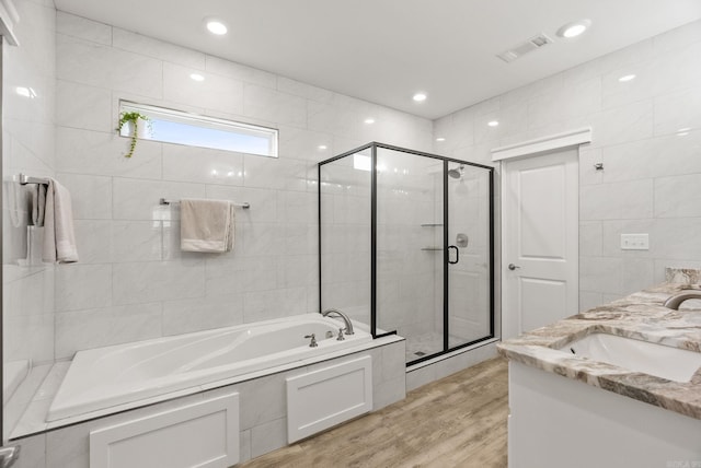 170 Irene Cir, Greenbrier, AR 72058 - bathroom with a bath, double vanity, a stall shower, wood finished floors, and tile walls