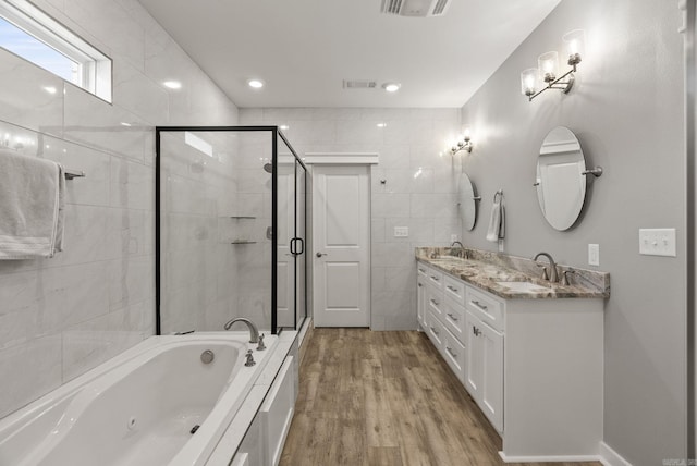 170 Irene Cir, Greenbrier, AR 72058 - bathroom featuring a tub with jets, double vanity, a stall shower, wood finished floors, and tile walls